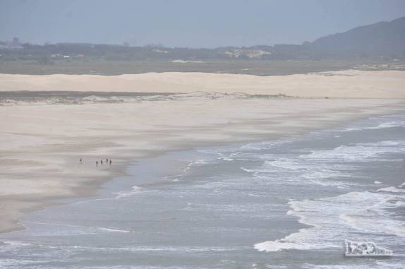 Ao longe, caminhantes solitários na enorme Praia da Galheta, no Farol de Santa Marta, litoral sul de Santa Catarina